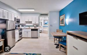 una cucina con armadi bianchi e parete blu di Grand Seas Resort a Daytona Beach