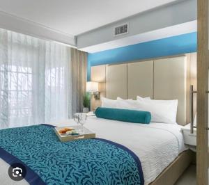 una camera d'albergo con un grande letto e un vassoio di Grand Seas Resort a Daytona Beach