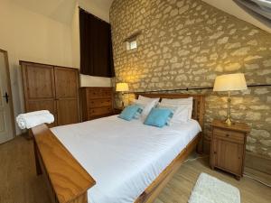 a bedroom with a large white bed with blue pillows at Barn in Aubigné-Racan with Heated Pool in Aubigné-Racan +15 photos