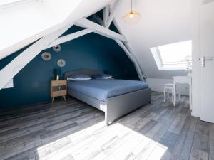 a blue bedroom with a bed and a window at Apartment in Le Mans near City Center in Le Mans