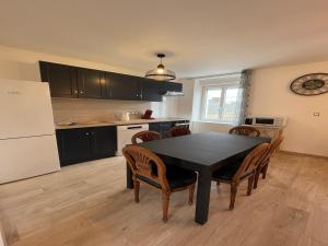 a kitchen with a table and chairs and a refrigerator at Duplex in Noyen-sur-Sarthe near Le Mans in Noyen-sur-Sarthe
