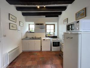 una cucina con elettrodomestici bianchi e un pavimento in mattoni di Stone House in Sarthe with Historic Chapel a Thorée-les-Pins Altre 8 foto