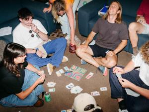 a group of people sitting on the floor playing a video game at Attic Backpackers in Auckland
