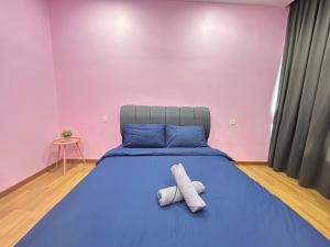 a bedroom with a blue bed with two towels on it at Sky Garden Ipoh Comfortable Homestay 6-7pax SY27 in Chemor