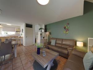 a living room with a couch and a table at Sunny Garden Stay near Sea in Wemeldinge