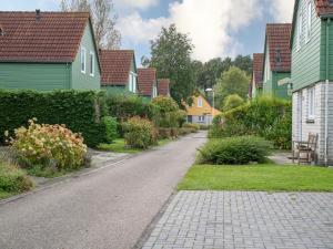 a street in a residential neighborhood with colorful houses at Sunny Garden Stay near Sea in Wemeldinge