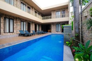 a swimming pool in the middle of a building at Kris Residence Sanur in Sanur