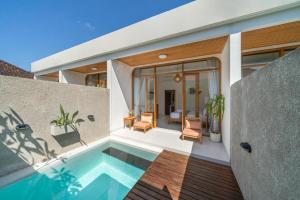 a house with a swimming pool in the backyard at Comoda Seminyak in Seminyak