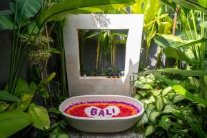 a bath tub filled with flowers in front of a mirror at Villa Seimbang by BaliSuperHost in Ubud