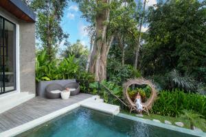 a garden with a swimming pool and a house at Villa Seimbang by BaliSuperHost in Ubud