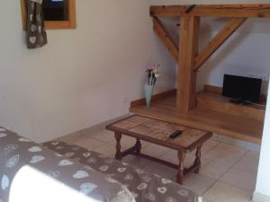 a room with a bed and a table with a tv at Gîte du Champ du Bois : Confort au cœur des Vosges - FR-1-589-820 in Le Tholy +11 photos