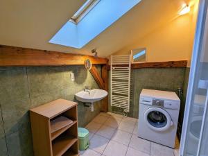 a bathroom with a washing machine and a sink at Gîte du Champ du Bois : Confort au cœur des Vosges - FR-1-589-820 in Le Tholy