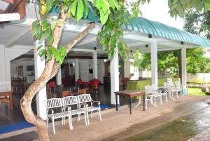 a group of chairs and tables under a building at Hotel Romi Gampaha in Gampaha