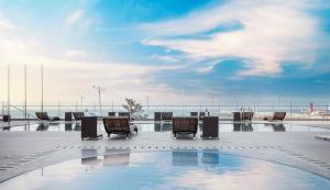 a large pool filled with lots of chairs and umbrellas at Hotel Regent Marine The Blue in Jeju