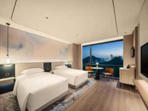 Postel nebo postele na pokoji v ubytování Aden Hotel Shenzhen Nanshan