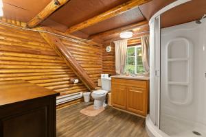 baño con aseo y pared de madera en Log Cabin at Rainier Lodge (0.4 miles from entrance), en Ashford 28 fotos más