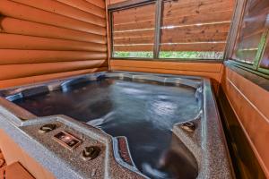a hot tub in a sauna with a window at Smoky Peak Retreat in Pigeon Forge