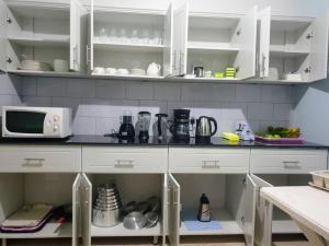 una cucina con armadietti bianchi e bancone di Grafo a Kampala Altre 12 foto