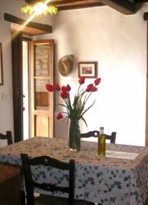 a table with a vase with red flowers on it at Ciliegio in Cortona