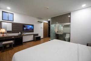 a bedroom with a white bed and a bathroom at Chiic House Hotel - Khách sạn tình yêu in Nha Trang +96 photos