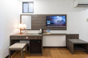 a room with a desk with a tv on the wall at Chiic House Hotel - Khách sạn tình yêu in Nha Trang