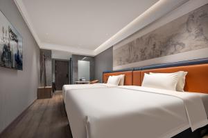 Rúm í herbergi á Yuanshe Yiju Hotel