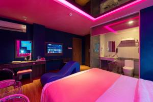 a bedroom with a bed and a bathroom with pink lights at Chiic House Hotel - Khách sạn tình yêu in Nha Trang