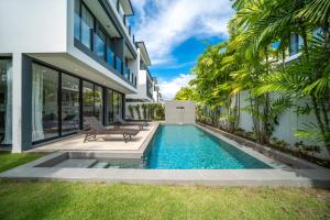 a swimming pool in the backyard of a house at Modern Minimalist 6 Bedroom Light Luxury Villa Private Pool Golf Course Laguna Park in Ban Phru Champa