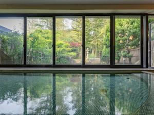 a house with a swimming pool and windows at Livemax Resort Yuhigaura Kitu Onsen in Kyotango