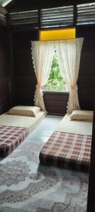 Postel nebo postele na pokoji v ubytování Rumah Kayu Masjid Zahir