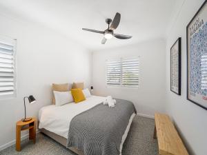 a bedroom with a bed and a ceiling fan at Pinnacles unit 23 Caloundra QLD in Caloundra