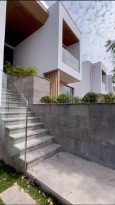 una casa bianca con delle scale davanti di VIERA Novaworld Phan Thiet Golf Villa a Phan Thiet
