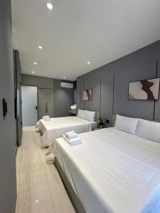 una camera da letto con due letti con lenzuola bianche di VIERA Novaworld Phan Thiet Golf Villa a Phan Thiet
