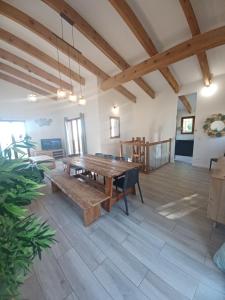 ein großes Wohnzimmer mit einem Holztisch und einer Bank in der Unterkunft Villa Padulina au bord de la mer avec piscine in Galeria