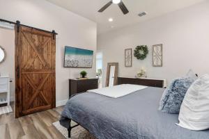 a bedroom with a bed and a wooden door at Riverscape Townhome B, Steps to Gruene Hall! in New Braunfels