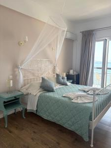 a bedroom with a bed with a canopy at Eros Beach Hotel in Benitses