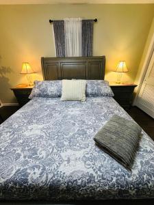 a bedroom with a blue and white bed with two lamps at The Soft Landing Elle's Home Near NYC in Trenton