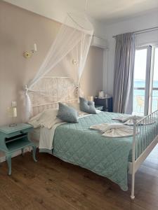 a bedroom with a large bed and a window at Eros Beach Hotel in Benitses