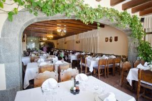 a dining room with white tables and chairs at Ca La Maria in Tordera