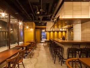 a restaurant with wooden tables and chairs and a bar at APA Hotel Ginza Kyobashi Tokyo-Eki Yaesu Minami-guchi in Tokyo