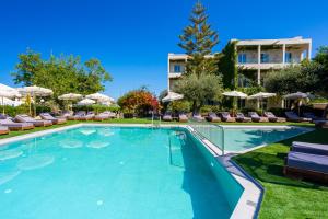 a large swimming pool with chairs and umbrellas at Dias by Azul Collection in Adelianos Kampos