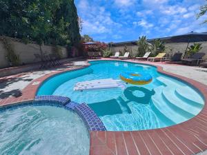 a large swimming pool with a pool noodle in it at Disneyland Paradise 6 BedRoom 4 Bathroom Pool Spa Games in Anaheim