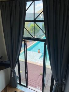 a view of a swimming pool from a window at Adoor hotel Khao Yai in Ban Rai