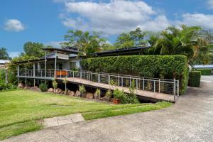 a house with a fence in front of it at Red Bridge Motor Inn in Woombye