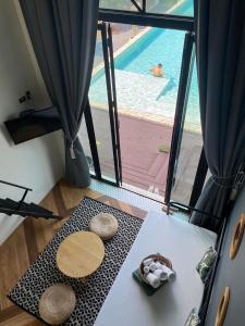 a room with a table with a view of a pool at Adoor hotel Khao Yai in Ban Rai