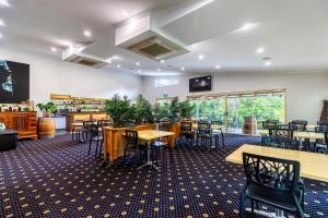 a restaurant with tables and chairs in a room at Red Bridge Motor Inn in Woombye +52 photos