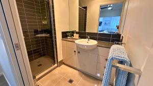 Sienna Rise - Walk to Westfield sleeps 6 North Lakes في البحيرات الشمالية: حمام مع حوض ودش مع مرآة +9 صور