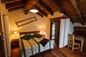 1 dormitorio con 1 cama en una habitación con techos de madera en La Maison D'Antan, en Bionaz