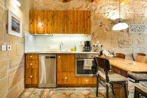 a kitchen with wooden cabinets and a wooden table at Cosy Haven, 96 Triq il-Karita', Victoria Gozo in Victoria +17 photos