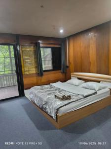 a bedroom with a large bed with a wooden headboard at Hill Tribe Art House (Lahu & Akha Homestay) in Ban Khrae Yao Doi Bo